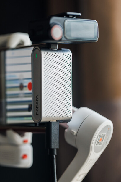 Modular lighting and mounting system with stacked components including a carbon-fiber case, LED panel, and reflector attached to a vertical pole.