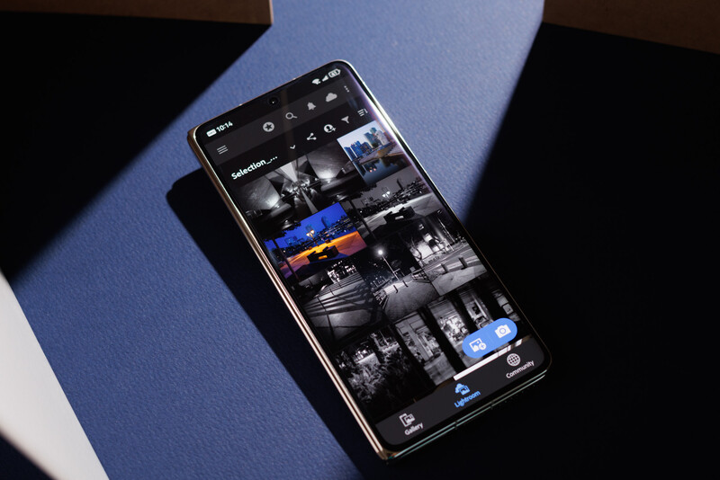 Smartphone displaying a grid of black and white photographs with one color image in the collection.