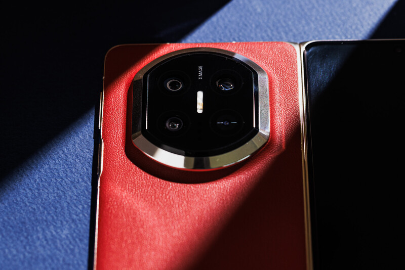 Close-up of a smartphone's camera module with hexagonal lens array mounted on a red leather back panel.