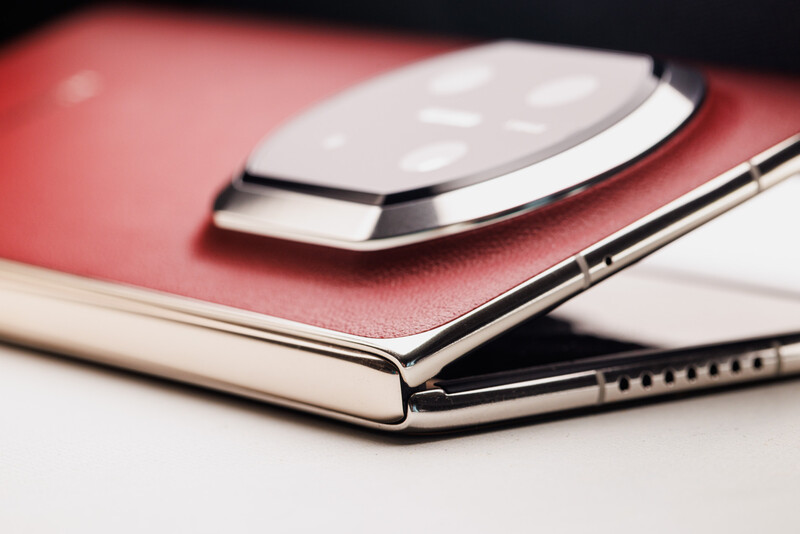 White wireless mouse resting on an open notebook with red and cream covers.