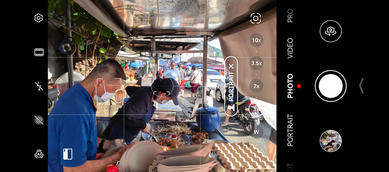 Screenshot of smartphone camera interface showing a street food vendor scene with multiple zoom options and format controls visible.