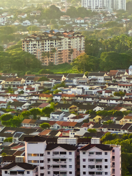 Aerial view of residential apartment buildings and low-rise homes in a densely populated urban neighborhood.