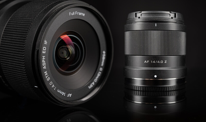 Two camera lenses arranged side-by-side against a dark background, showing optical and mechanical design details.