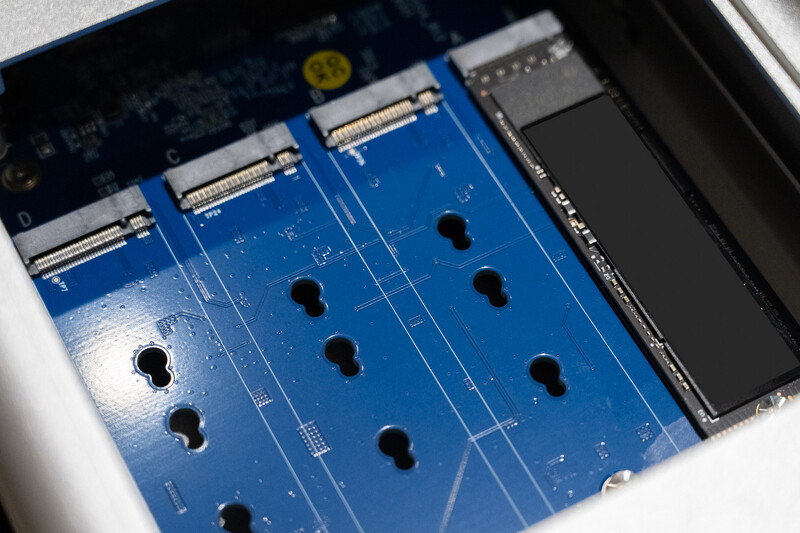 Close-up of a blue circuit board with multiple black connectors mounted in a computer chassis.