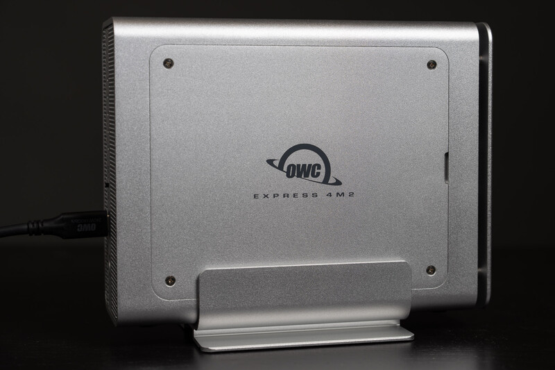 OWC Express 4M2 external storage drive with aluminum enclosure and stand, photographed against dark background.