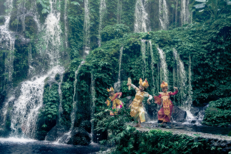 A photoshoot featuring traditional Balinese dancers in front of a waterfall.