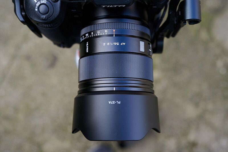 Telephoto lens mounted on camera body, showing focusing ring and depth-of-field scale markings.