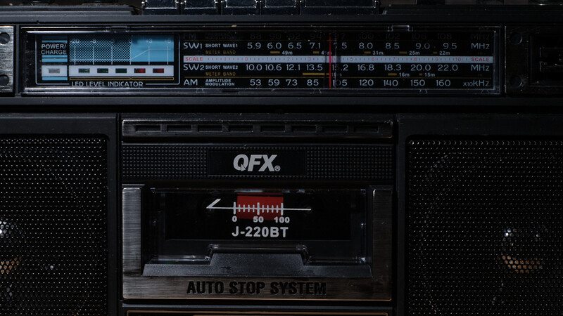 Vintage QFX boombox with dual cassette decks and AM/FM radio tuner display.