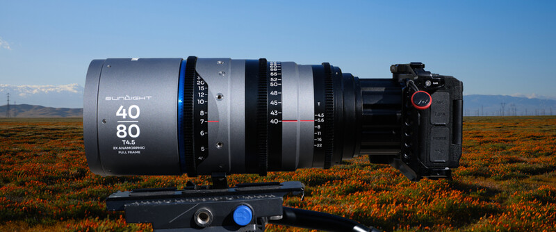 Anamorphic cinema lens mounted on camera body with focus and aperture rings visible against desert landscape.