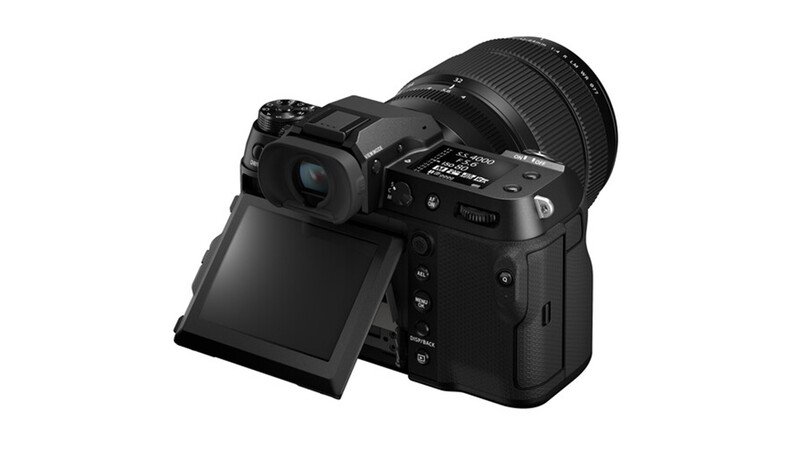 Professional mirrorless camera with articulating touchscreen and telephoto lens attached, shown at three-quarter angle.