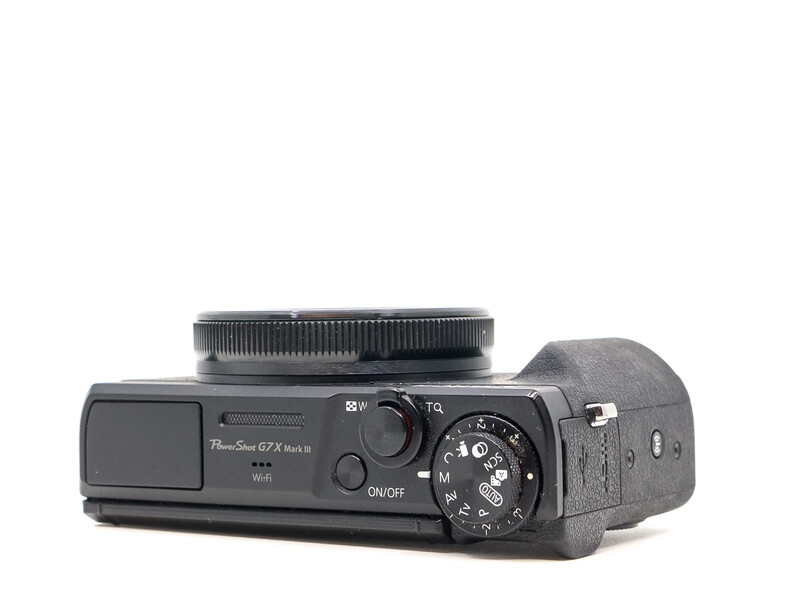 Canon PowerShot G7X Mark II compact camera shown from the side with lens extended upward.