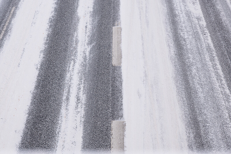 Aerial view of plowed agricultural fields with alternating dark and light soil stripes creating geometric patterns.