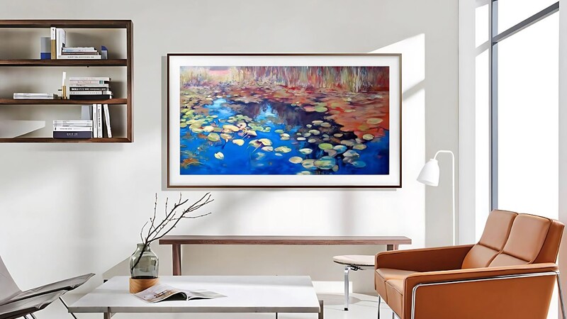Modern office interior with framed landscape photograph of lily pads on blue water displayed above a wooden desk.