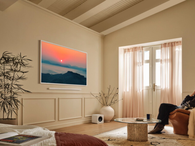 Sunset landscape photograph hung above wainscoting in a minimalist bedroom interior.