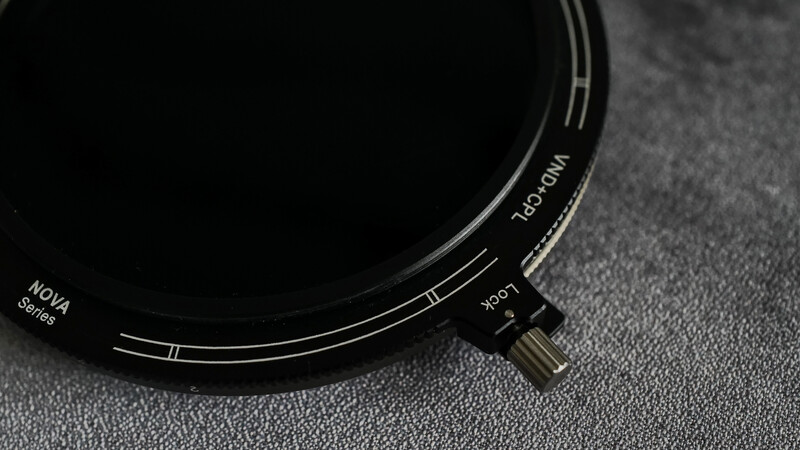 Hoya circular filter with adjustment dial and markings visible on dark textured surface.