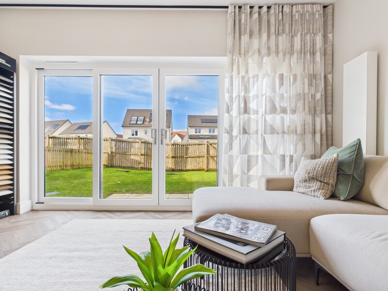 Bright bedroom with French doors opening to a manicured backyard with neighboring houses visible.