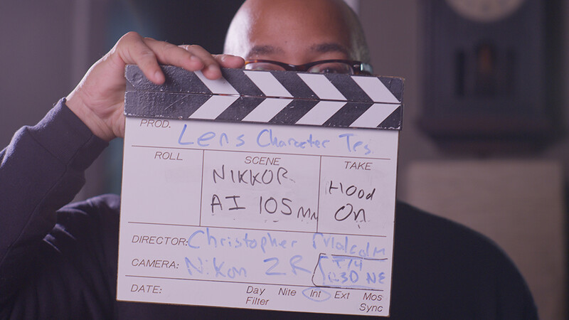 Director holds a film clapperboard with handwritten production details during a shoot.