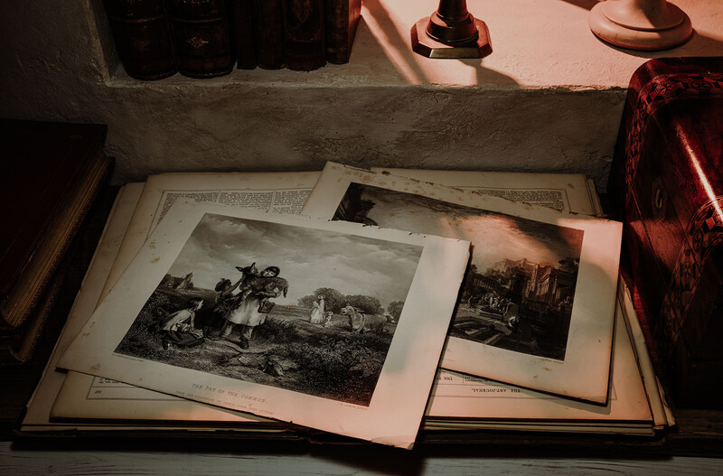 Open book displaying classical engraved prints and lithographs on aged pages.