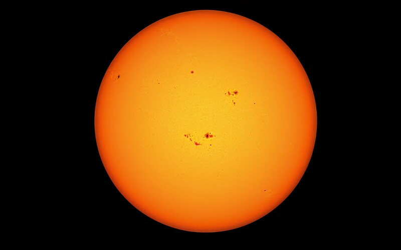Sun's disk with visible sunspots and solar features against black space.