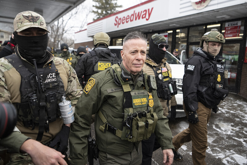 Law enforcement officers in tactical gear and uniforms conduct operations outside a Speedway gas station.