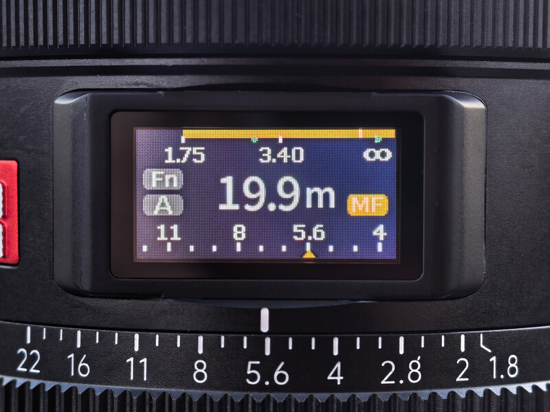 Camera viewfinder display showing focus distance of 19.9 meters and depth of field scale with aperture and focal length information.