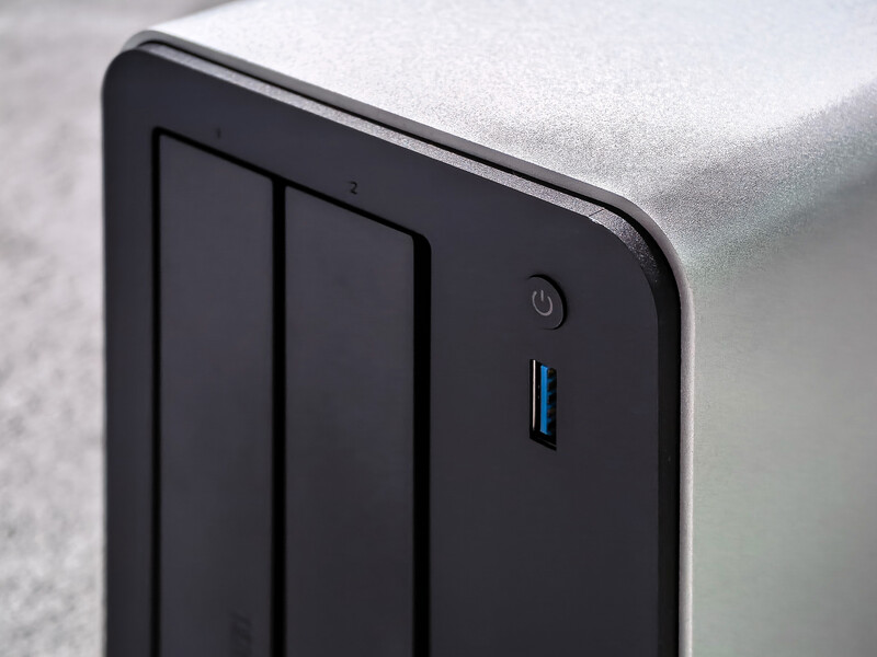Close-up of a black external hard drive showing two drive bays and a power button with blue indicator light.