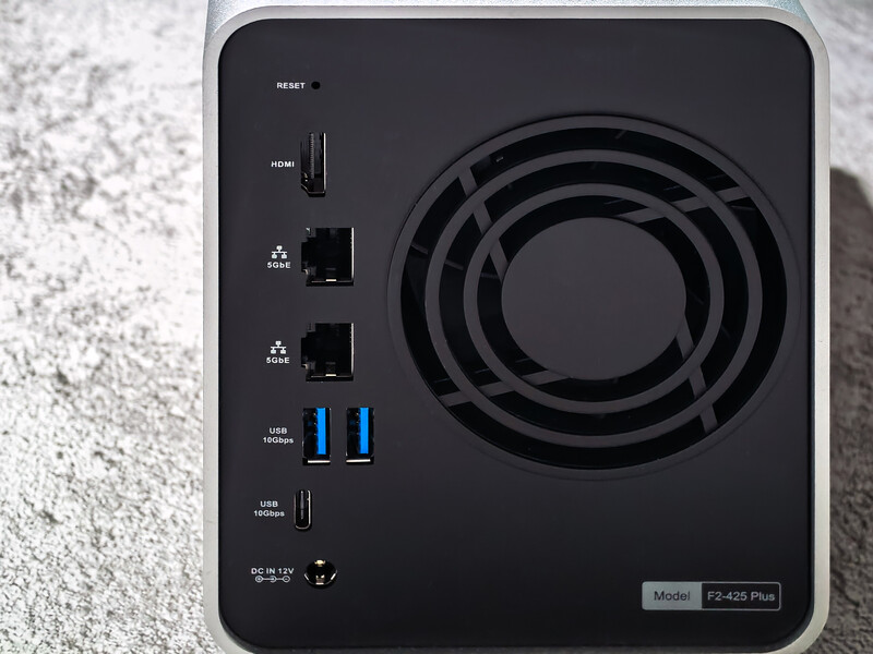 Back panel of a compact network storage device showing cooling fan, multiple USB ports, and control buttons.