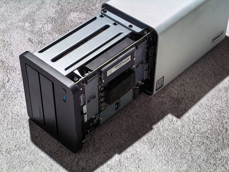 Disassembled digital camera showing internal components and sensor mechanism on gray carpet.