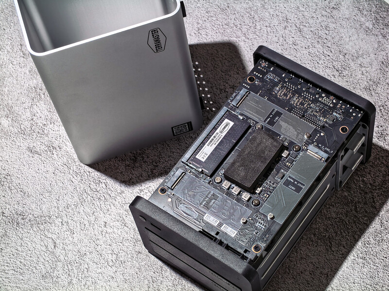 Computer tower with opened base panel revealing internal components including circuit boards and RAM modules.