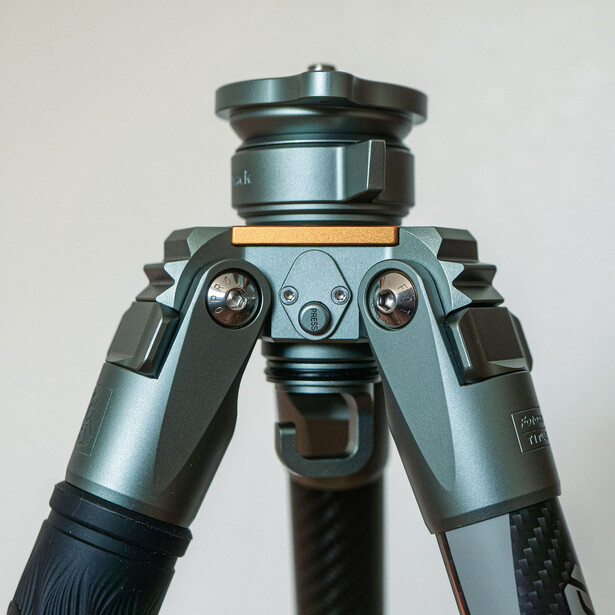Professional tripod head with gray metal construction and dual handles mounted on black leg.