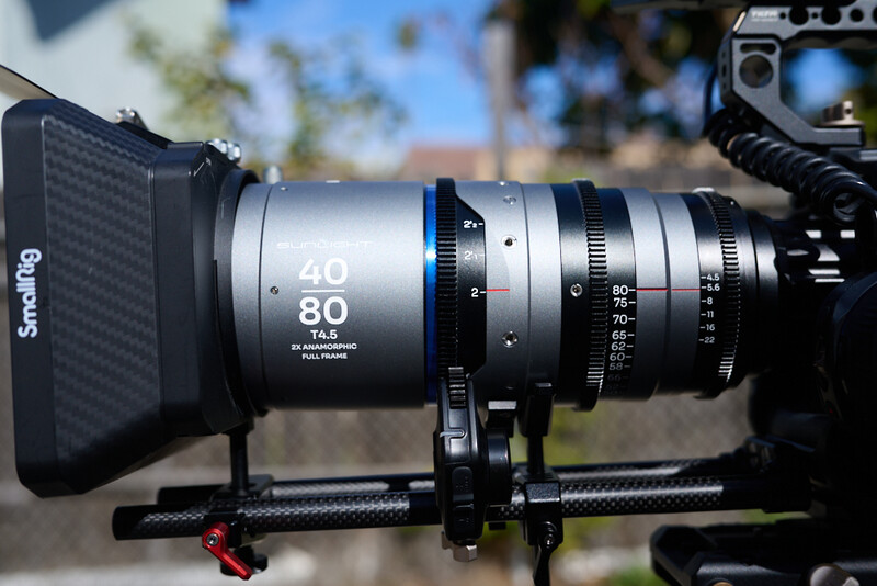 Zoom lens mounted on cinema camera with follow focus and matte box in outdoor setting.