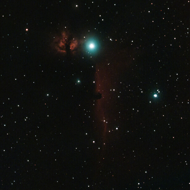 Deep space astronomical observation showing dark nebula with embedded bright blue star and reddish emission regions surrounded by background stars.