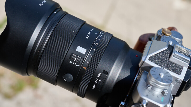 Modern mirrorless camera with mounted prime lens featuring focus and aperture rings.