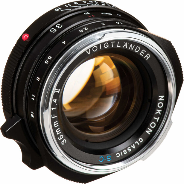 Voigtlander manual focus lens with golden-amber glass elements visible through the front, mounted on a black camera body.