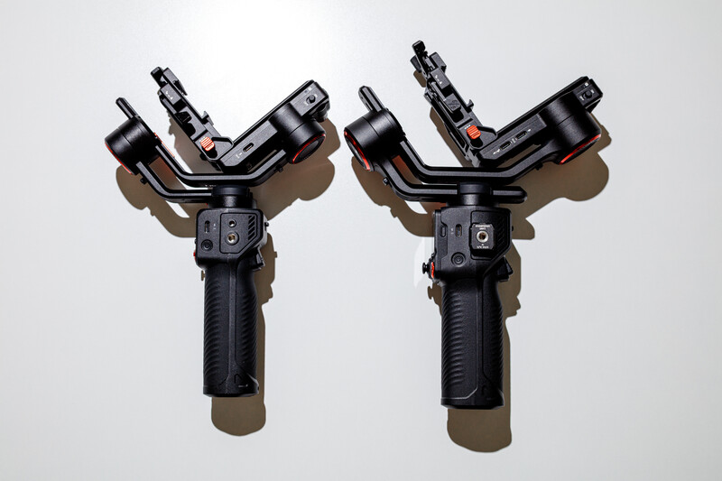 Two identical three-axis motorized gimbals with handles positioned side by side against a white background.