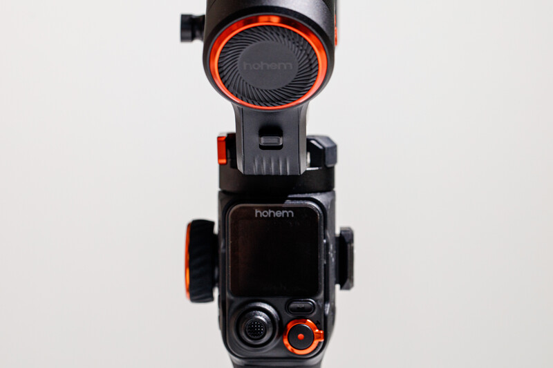 Handheld camera gimbal with black body and red accents, shown from directly above against white background.
