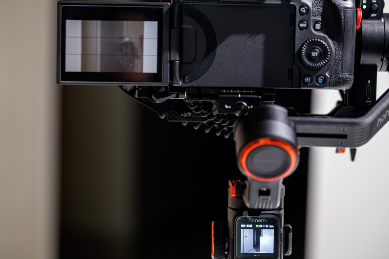 Top-down view of a mirrorless camera with articulating screen and gimbal stabilizer mounted below.