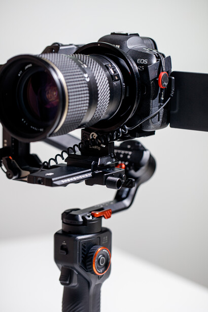 Mirrorless camera mounted on a three-axis gimbal stabilizer against a white background.