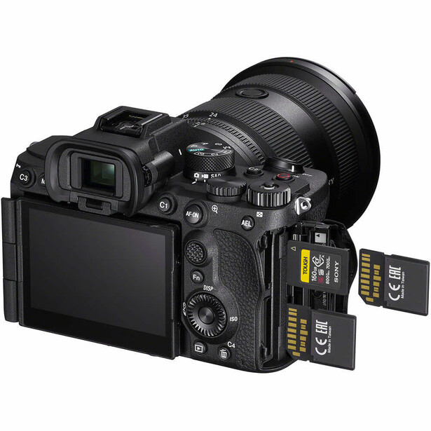 Professional mirrorless camera with attached telephoto lens and two memory cards displayed alongside.