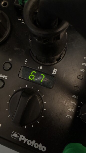 Close-up of a Profoto lighting control panel displaying an ISO setting of 67 on the green digital readout.
