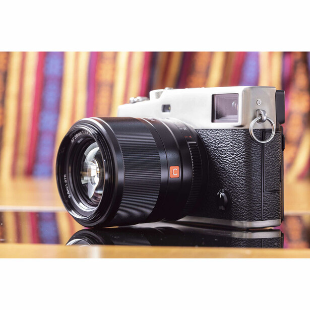 Rangefinder film camera with black leather body paired with a fast prime lens featuring an orange accent ring.