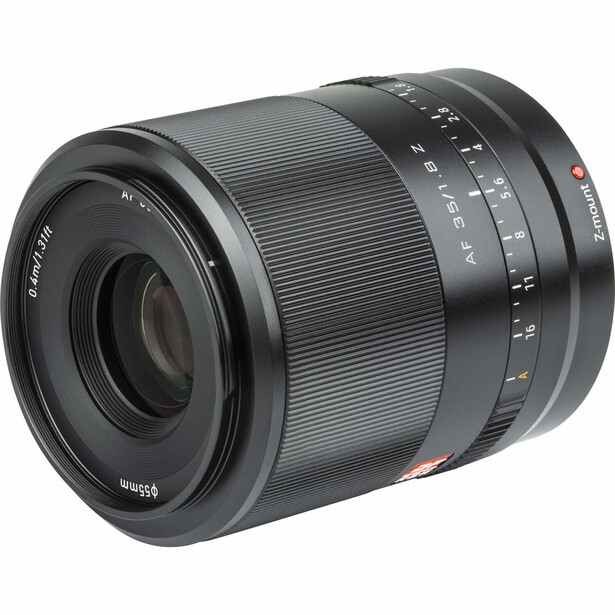 Black prime lens with manual focus ring and depth-of-field scale against white background.