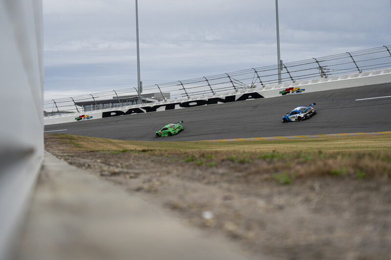 Two Porsche's race through speedway turn four at the Daytona International Speedway