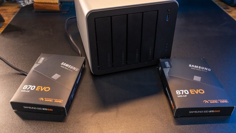 Two Samsung 870 EVO SSD boxes and a five-bay NAS enclosure arranged on a dark desk.