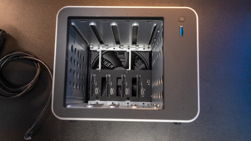 Interior view of a desktop computer tower showing dual cooling fans and four storage drives mounted in drive bays.