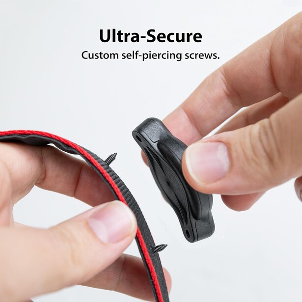 Close-up of hands holding a black self-piercing screw connector next to red and white wiring.