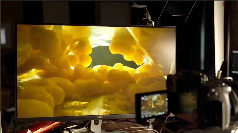 Monitor displaying macro footage of yellow illuminated organic forms with a small preview screen visible to the right.