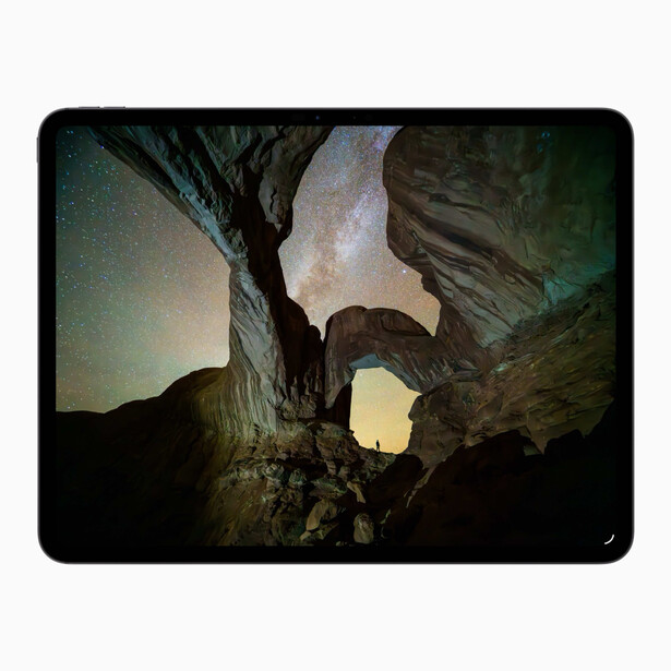 View through a natural rock arch opening to a distant glowing horizon with layered sky at dusk or dawn.