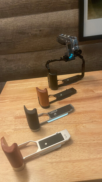 Collection of four wooden-handled hammers arranged on a wooden surface next to a clamp.