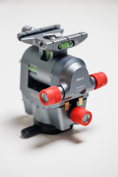 Fluid head tripod with spirit level and red leg locks on white background.